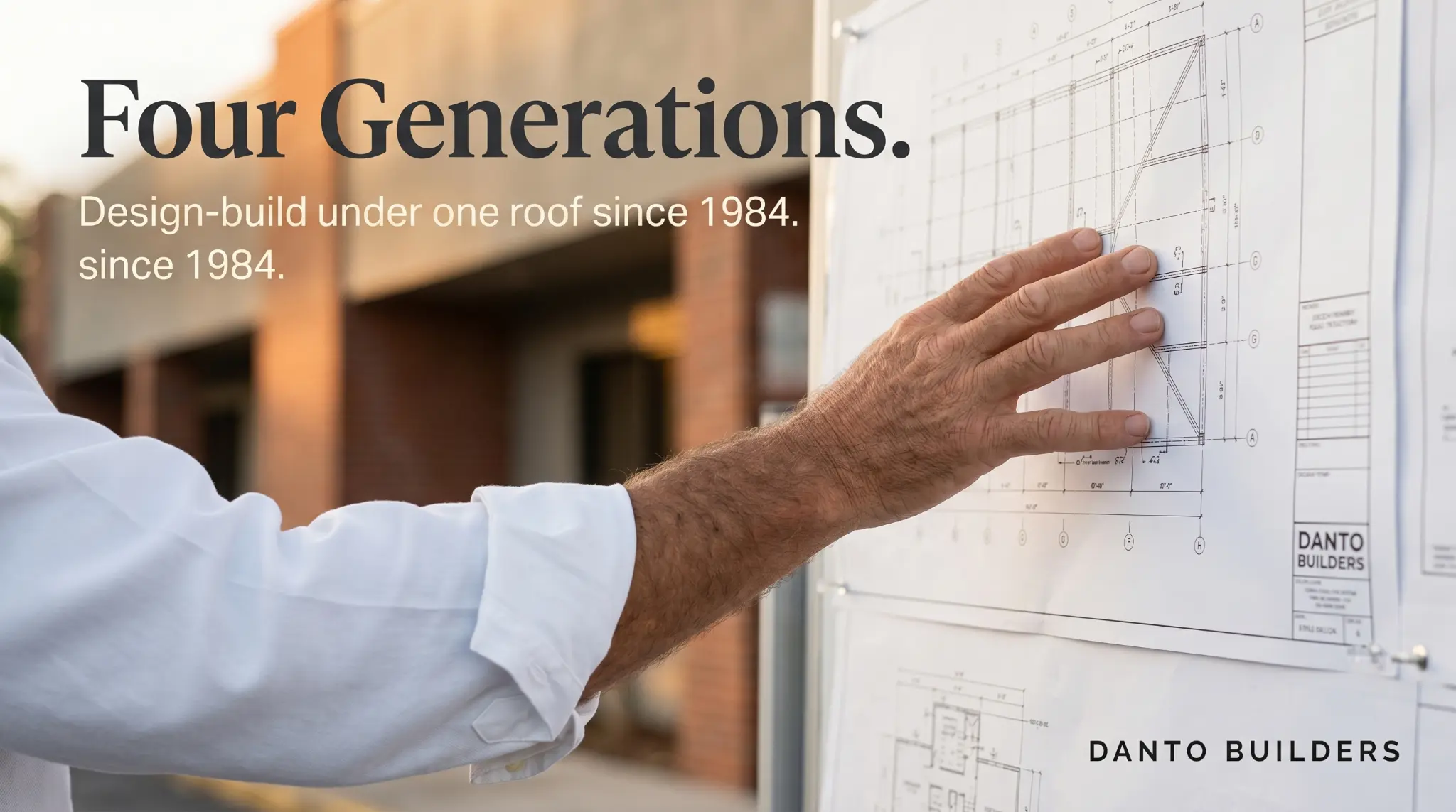 Four Generations brand hero — man pointing at blueprints on wall